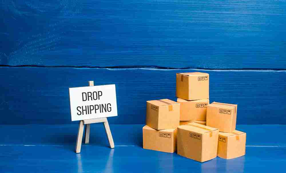 piles of cardboard boxes and drop shipping sign on side