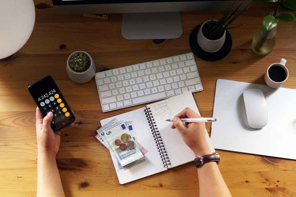 a person verifiying his finances on copy with calculator